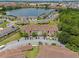 Aerial view shows a condo building near a lake with parking and green space around it, and surrounding community at 621 Terrace Ridge Cir # 621, Davenport, FL 33896