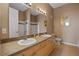 Well-lit bathroom showcases a double sink vanity, a large mirror, and tiled floors at 621 Terrace Ridge Cir # 621, Davenport, FL 33896