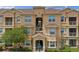 Close-up view of a condo building featuring multiple stories with private patios, lovely landscaping and manicured bushes at 621 Terrace Ridge Cir # 621, Davenport, FL 33896