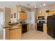 Open-concept kitchen featuring black appliances, wood cabinets, and tile flooring at 621 Terrace Ridge Cir # 621, Davenport, FL 33896