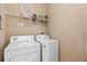 Convenient laundry room featuring a washer, dryer, and shelving for storage at 621 Terrace Ridge Cir # 621, Davenport, FL 33896