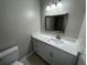 This bathroom has a vanity with white cabinets, a white countertop, and a framed mirror at 6624 Kristin Ct, Orlando, FL 32818