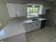 Updated kitchen featuring white cabinets, modern countertops, stainless steel sink, and tile floors at 6624 Kristin Ct, Orlando, FL 32818