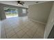 Large living room with tiled flooring, ceiling fan, and sliding glass door to the back yard at 6624 Kristin Ct, Orlando, FL 32818