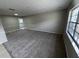 Spacious living room featuring neutral carpet, a large window and decorative trim at 6624 Kristin Ct, Orlando, FL 32818