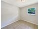 Bright bedroom features neutral paint, tile floor, and natural light from a window at 7614 Sw 80Th St, Ocala, FL 34476
