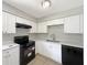Modern kitchen featuring white cabinets, black appliances, and ample counter space at 7614 Sw 80Th St, Ocala, FL 34476