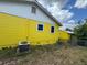 Back exterior featuring yellow siding and an updated HVAC system near an outbuilding at 825 Poinsettia Dr, Eustis, FL 32726
