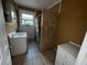 Modest bathroom featuring a tile shower, single sink vanity, and a window for natural light at 825 Poinsettia Dr, Eustis, FL 32726