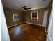 View of a bedroom with two windows, ceiling fan, and hardwood floors at 825 Poinsettia Dr, Eustis, FL 32726