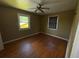 Bedroom features hardwood floors, a ceiling fan, and two windows with natural light at 825 Poinsettia Dr, Eustis, FL 32726