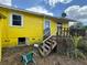 Exterior image of the home with a yellow siding, a small deck, and a side door at 825 Poinsettia Dr, Eustis, FL 32726