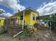 View of the yellow house with a deck, patio, and a well landscaped exterior at 825 Poinsettia Dr, Eustis, FL 32726
