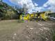 View of the yellow house with a backyard shed and deck at 825 Poinsettia Dr, Eustis, FL 32726