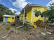 View of the backyard of a yellow home with a deck and detached shed at 825 Poinsettia Dr, Eustis, FL 32726