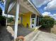 Charming home featuring a covered porch, yellow siding, and a screened-in patio at 825 Poinsettia Dr, Eustis, FL 32726