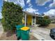 Charming home featuring a covered porch, yellow siding, and two green trash cans at 825 Poinsettia Dr, Eustis, FL 32726