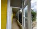 View of an enclosed porch with yellow siding and a black chair at 825 Poinsettia Dr, Eustis, FL 32726