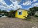 Charming home featuring yellow siding, a metal roof, and a bright blue shutter at 825 Poinsettia Dr, Eustis, FL 32726