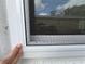 Close up of an exterior window with a bright white trim and screen at 825 Poinsettia Dr, Eustis, FL 32726