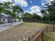 View of a large yard with a partial fence, trees, and a home visible in the background at 825 Poinsettia Dr, Eustis, FL 32726