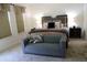 Bright bedroom featuring a gray settee, plush carpet, and a comfortable king-size bed at 9005 Reflection Pointe Dr, Windermere, FL 34786
