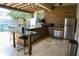 Outdoor kitchen with stainless steel appliances, granite countertops, and shaded pergola at 9005 Reflection Pointe Dr, Windermere, FL 34786