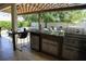 Outdoor kitchen with stainless steel appliances, granite countertops, and shaded pergola at 9005 Reflection Pointe Dr, Windermere, FL 34786
