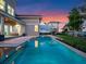 Sunset lights up the backyard with pool, spa and lake views, from the home's covered patio at 9916 Lone Tree Ln, Orlando, FL 32836