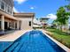 Expansive backyard featuring a sparkling pool, lush lawn, and waterfront access at 9916 Lone Tree Ln, Orlando, FL 32836