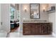 Bathroom vanity with granite counters, dark wood cabinetry, a large mirror, and an adjacent sitting room with water view at 9916 Lone Tree Ln, Orlando, FL 32836