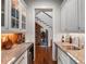 Butler's pantry view featuring granite counters, wine storage, and view to staircase at 9916 Lone Tree Ln, Orlando, FL 32836