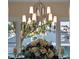 Close up of a polished chrome chandelier hanging over a dining table and flower arrangement at 9916 Lone Tree Ln, Orlando, FL 32836