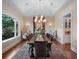 Formal dining room showcases a large table, statement chandelier, and backyard views at 9916 Lone Tree Ln, Orlando, FL 32836