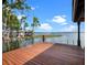 Gorgeous wood dock overlooking a serene lake with lush trees and a boathouse, perfect for enjoying waterfront living at 9916 Lone Tree Ln, Orlando, FL 32836