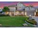 Gorgeous two-story home with impeccable landscaping, lush green lawns, and a welcoming facade at twilight at 9916 Lone Tree Ln, Orlando, FL 32836