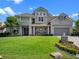 Attractive two-story home with a paved driveway, manicured lawn, and beautiful landscaping at 9916 Lone Tree Ln, Orlando, FL 32836