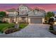 Attractive two-story home with a paved driveway, manicured lawn, and beautiful landscaping at 9916 Lone Tree Ln, Orlando, FL 32836