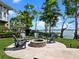 Charming stone fire pit and Adirondack chairs create an inviting outdoor space with a serene lake backdrop at 9916 Lone Tree Ln, Orlando, FL 32836
