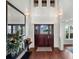 Bright foyer boasts hardwood floors, high ceilings, statement mirror, and a beautiful wood entry door at 9916 Lone Tree Ln, Orlando, FL 32836