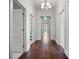 Hallway featuring hardwood flooring, white trim, paneled doors and a decorative transom window at the end of the hall at 9916 Lone Tree Ln, Orlando, FL 32836