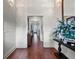 Long hallway featuring hardwood floors, white trim, and an eye-catching floral arrangement on a console table at 9916 Lone Tree Ln, Orlando, FL 32836