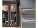 A close-up shows glass front cabinets displaying decorative objects next to a stainless steel refrigerator at 9916 Lone Tree Ln, Orlando, FL 32836