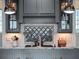 A detailed view of the kitchen island featuring a cooktop and decorative backsplash, enhanced by pendant lighting at 9916 Lone Tree Ln, Orlando, FL 32836