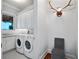 Bright laundry room equipped with modern washer and dryer, granite countertops, and overhead cabinets at 9916 Lone Tree Ln, Orlando, FL 32836