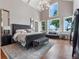 Luxurious primary bedroom featuring a stylish chandelier, large windows, and beautiful water views at 9916 Lone Tree Ln, Orlando, FL 32836