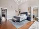 Primary bedroom featuring hardwood floors, a cozy sofa and bench, and stylish decor at 9916 Lone Tree Ln, Orlando, FL 32836