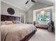 Bedroom suite featuring water views, window seat, vaulted ceilings, ceiling fan, and a dark wood sleigh bed at 9916 Lone Tree Ln, Orlando, FL 32836