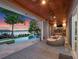 Covered patio boasts an outdoor kitchen and cozy seating area next to a sparkling pool and serene lake view at 9916 Lone Tree Ln, Orlando, FL 32836
