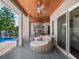Inviting covered patio with ceiling fan, outdoor kitchen and living area, overlooking the pool at 9916 Lone Tree Ln, Orlando, FL 32836